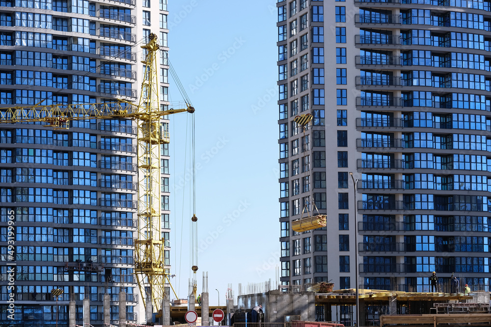 Construction of office buildings. A construction crane lifts materials. Builders work . High quality photo