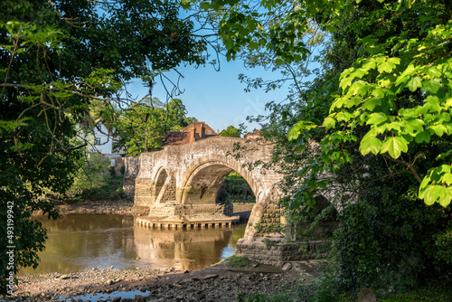 Leaves framed view to medieval Aylesford bridge and river in Kent, England