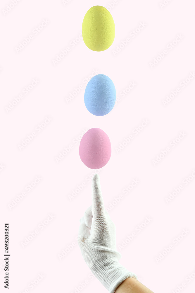 Three colored Easter eggs levitate above a human finger. Easter egg balance. Three colored Easter eggs levitate above a human finger. Easter egg balance.