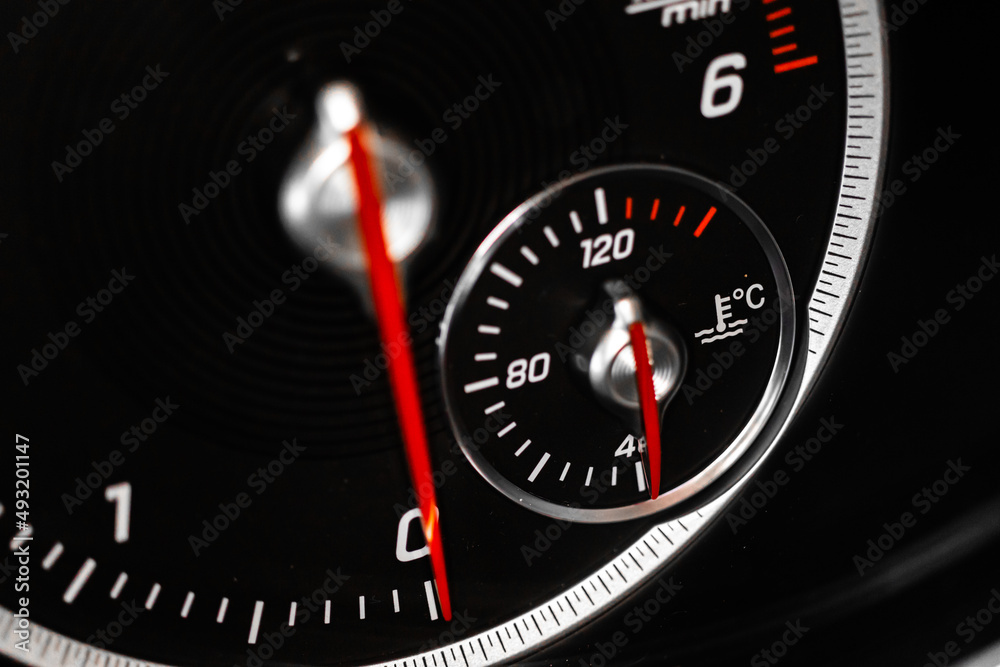 Cooling temperature gauge of a car, glowing indicator close-up view