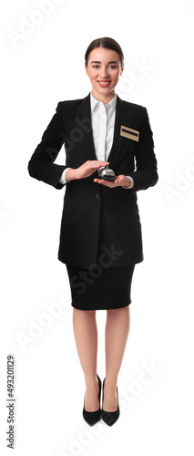 Happy young receptionist in uniform holding service bell on white background