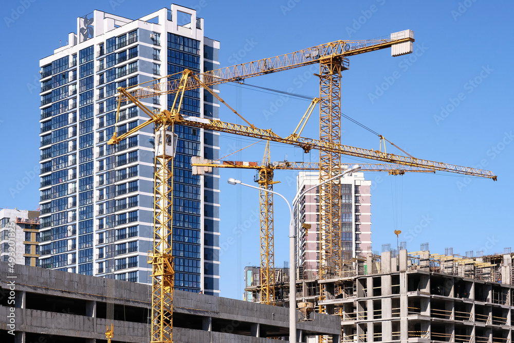 Construction cranes are working. Construction of modern buildings. Offices, mortgage . High quality photo