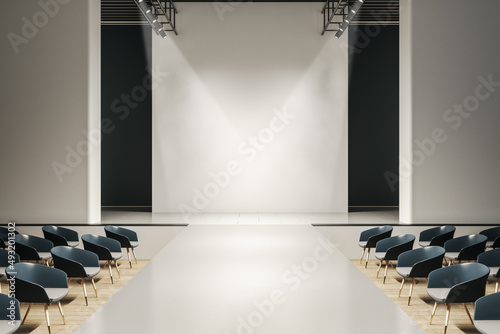 Contemporary concrete auditorium interior with seats, runway and empty mock up place on wall. Presentation and fashion concept. 3D Rendering. photo