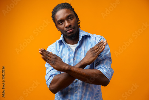 Cuadro en lienzo Portrait of serious African American male showing hand stop sign