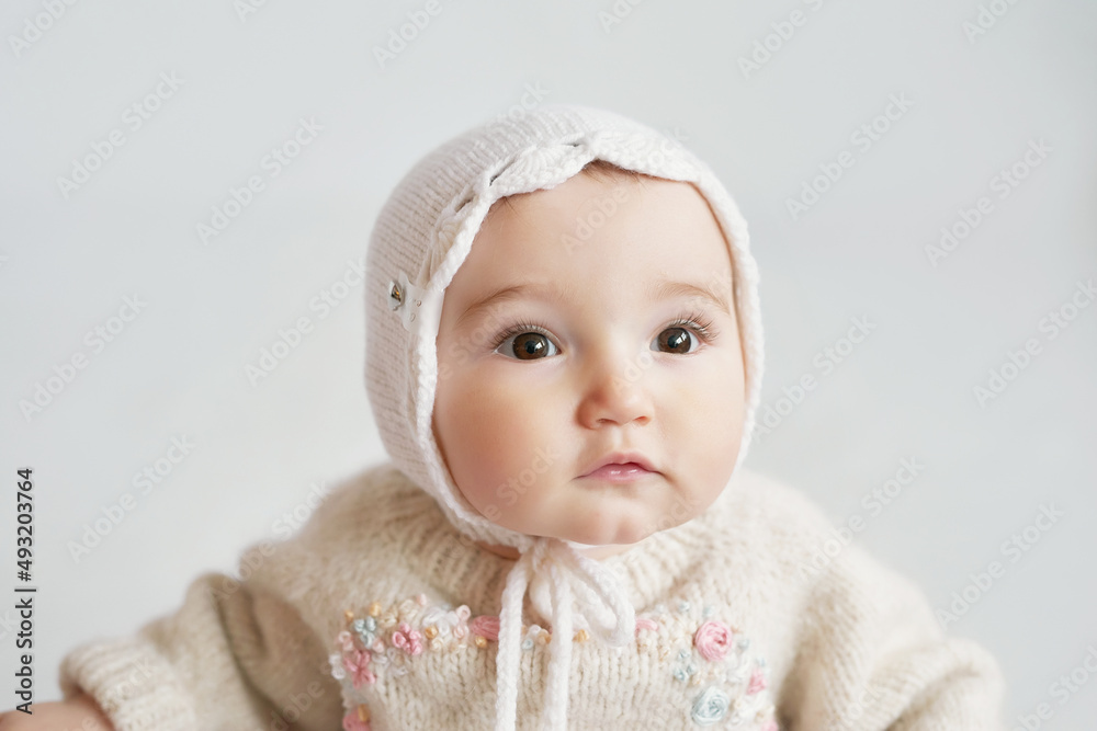 Cute baby girl in knitted clothes and hat with teddy bear toy. Children Protection Day. Mother's day greeting card. International day of happiness. Cute baby girl in knitted clothes and hat with teddy bear toy. Children Protection Day. Mother's day greeting card. International day of happiness.