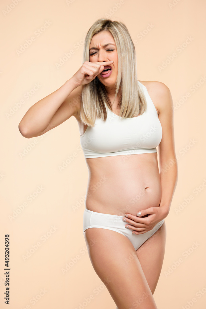 Young pregnent woman in lingerie disgusted suffering with nausea Young pregnent woman in lingerie disgusted suffering with nausea