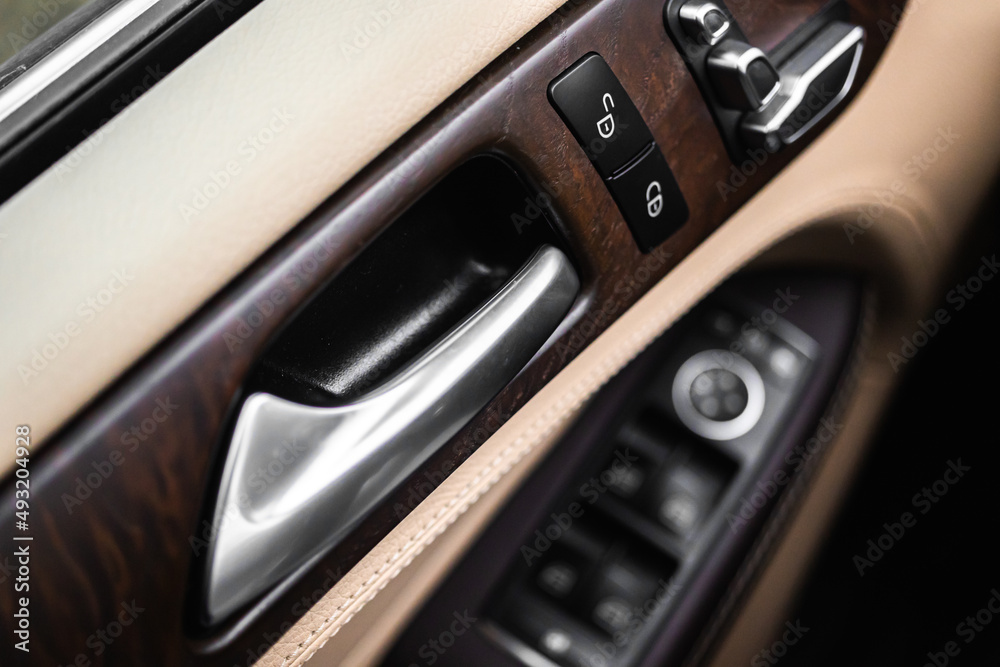 Car door handle inside luxury car interior with leather background, close-up view photo