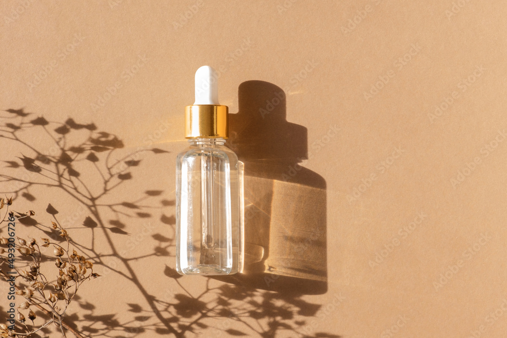 Naklejka premium Natural oil cosmetics on neutral background. Dropper glass Bottle Mock-Up. Oily cosmetic pipette. Face and body treatment. Spa concept. Mineral organic oil. Flat lay with beauty products. Blank bottle