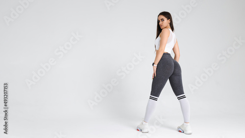 Portrait of a young athletic woman in sportswear in the studio on a white background