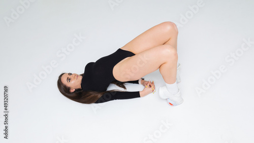 Girl doing a glute bridge exercise in the studio on a white background