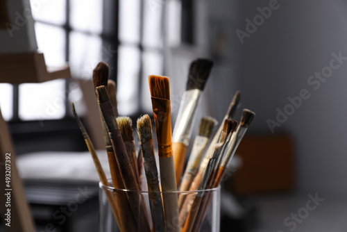 Holder with different brushes in artist's studio, closeup