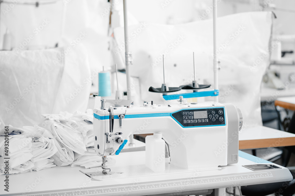 Concept Interior of garment factory. Automatic machine for embroidering patterns