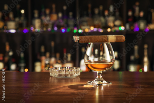 close up view of cigar and glass of cognac on color back.  © Dmitry Ersler