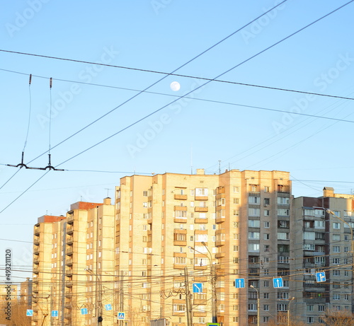 The moon in the evening blue sky over the city, Kollontai Street, St. Petersburg, Russia, March 2022