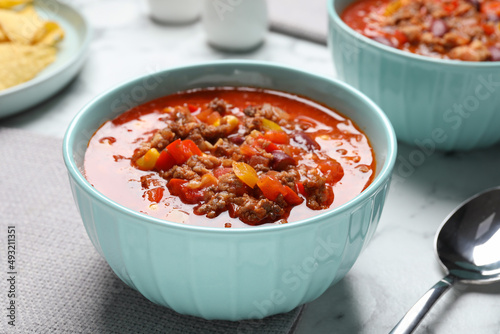 Tasty chili con carne on white table