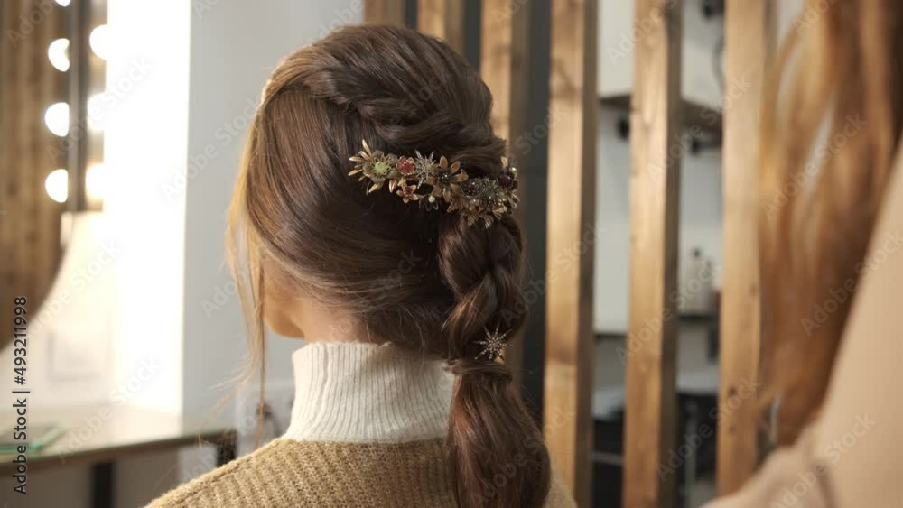 Hairdresser finishing hairstyle for her client at the hair salon.