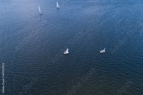 View from the air on the steppe river on a bright sunny day  on the river sailing boats. Sailing sports on the river.