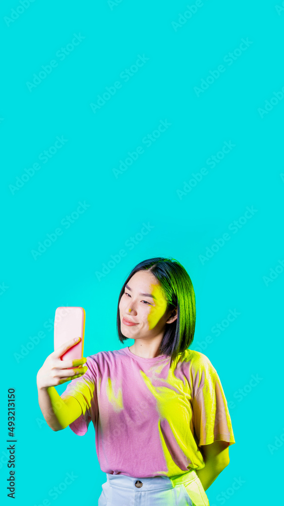 Young asiatic woman isolated using smartphone taking selfie Young asiatic woman isolated using smartphone taking selfie
