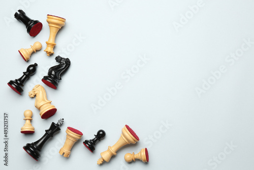 Many different chess pieces on white background, flat lay. Space for text photo