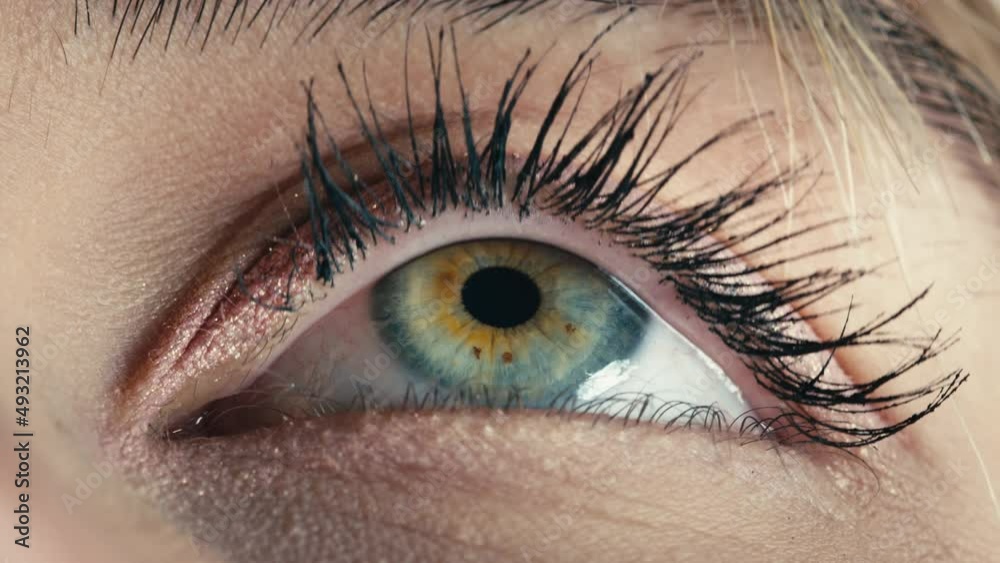 Blue eye of a beautiful model girl that opens slowly