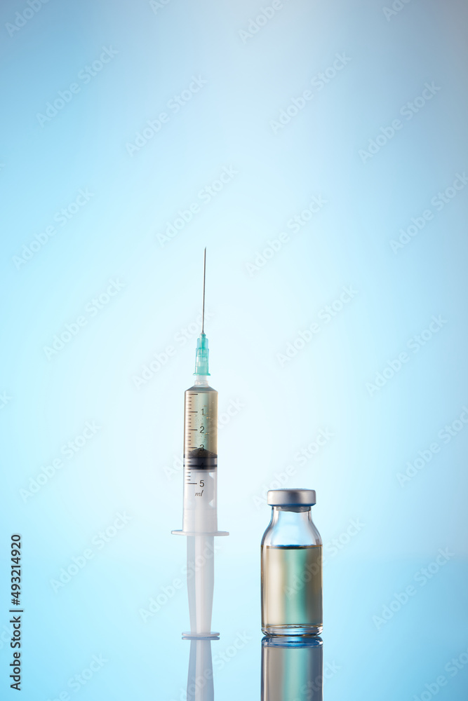 Syringe and Bottle on blue background Syringe and Bottle on blue background