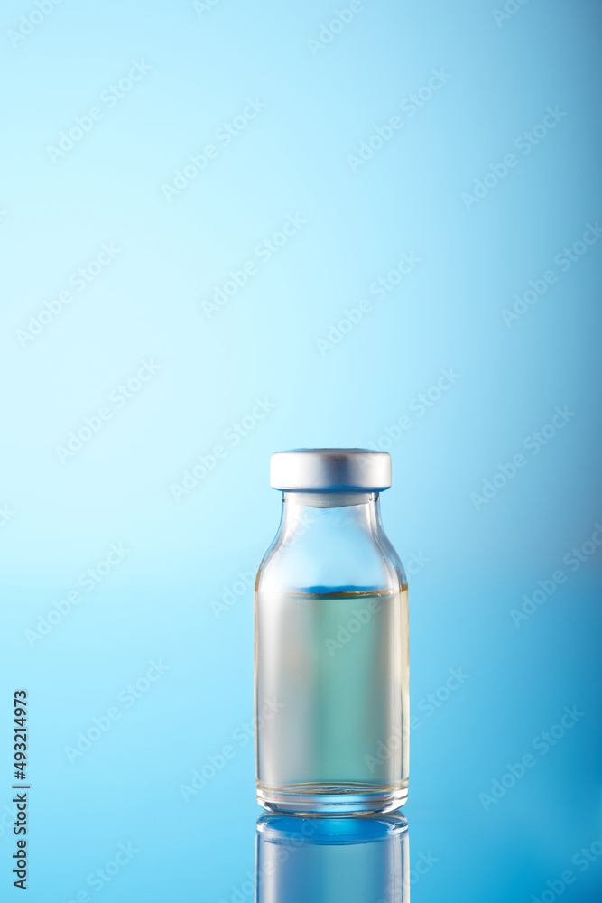 Vaccine injectable vials and syringe close up in blue tones Vaccine injectable vials and syringe close up in blue tones