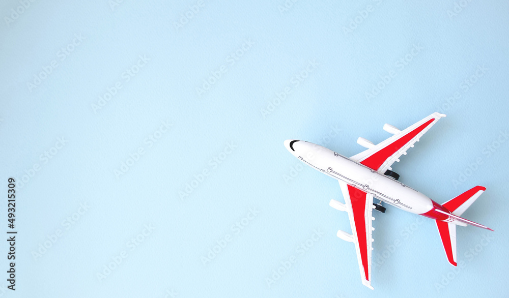 Naklejka premium Flat lay, airplane model on blue background. The concept of minimalism travel, vacation, vacation. Booking tickets online on the site. Space for copy text. Banner. Background picture.