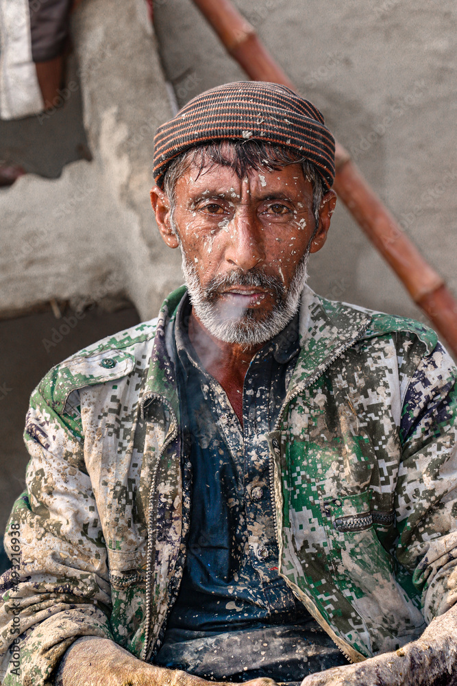 Obraz premium old labor worker is tired after hard work he smoking