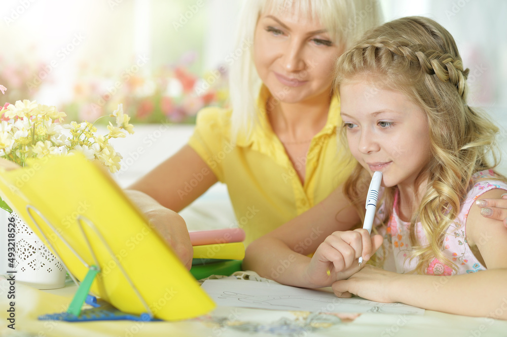 little cute girl with mother studying at home little cute girl with mother studying at home