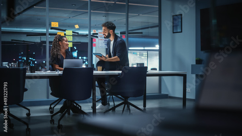 Businesspeople in Modern Office: Business Meeting of Two Managers. Female CEO and Marketing Director Talk, Brainstorm Corporate Strategy, Implementing Marketing and Financial Plans. Evening Time.