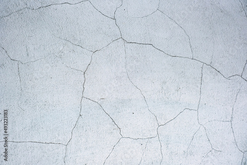 White black grey concrete wall, floor with cracks, texture background. The cracked white plaster wall. White wall with cracks. Crack white wall texture.
