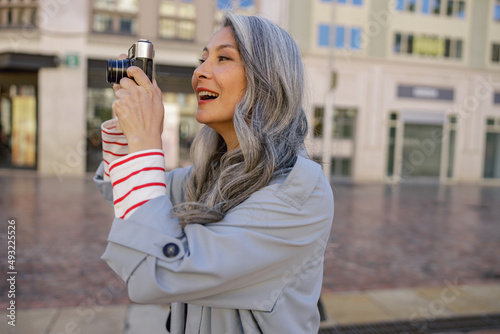 Attractive mature woman with camera on city street