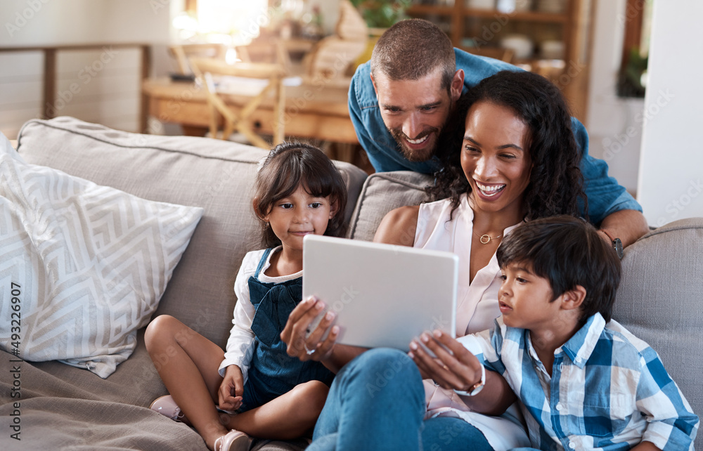 We found some online entertainment for the whole family. Shot of a family of four watching something on a digital tablet. We found some online entertainment for the whole family. Shot of a family of four watching something on a digital tablet.