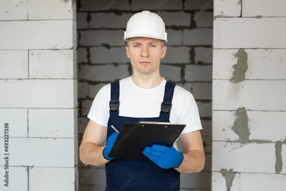 Construction engineer in a white helmet and a tablet on a construction site. Construction engineer in a white helmet and a tablet on a construction site.