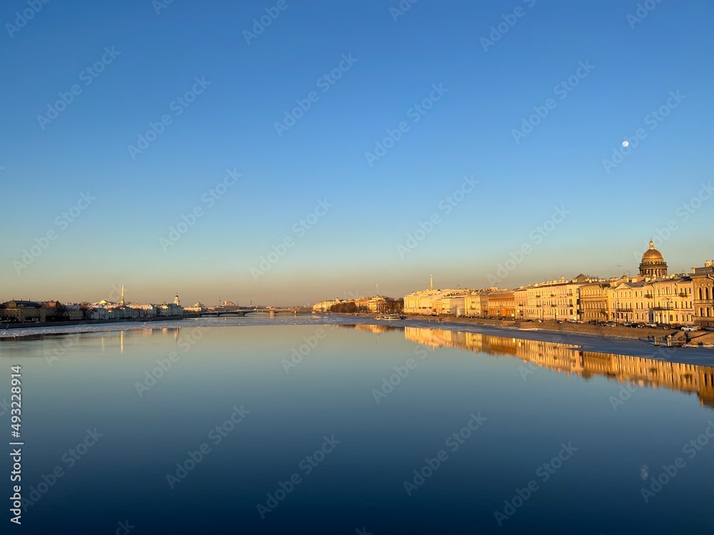 City river, blue sky, reflection on the water 