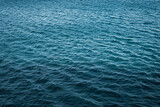 Calm deep blue sea with ripples on the surface of the water. Dark blue background and texture