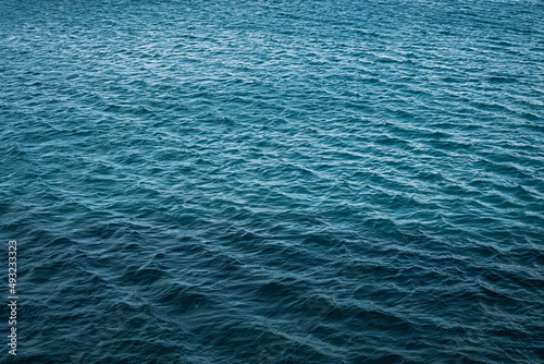 Calm deep blue sea with ripples on the surface of the water. Dark blue background and texture