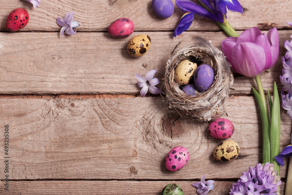 Easter eggs with spring flowers on wooden background