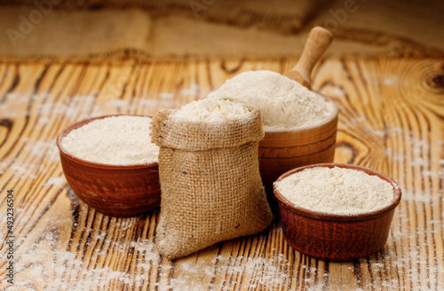 Flour in bowls and bags on a wooden background. High quality photo