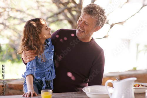 Love you so much my darling. Shot of a little girl and her grandfather having breakfast together outside.