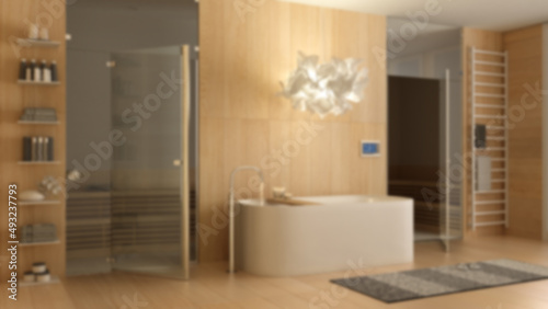 Blur background  modern wooden spa room  bathroom  wellness center with bathtub  sauna room with glass doors  rack with towels  shelves  lamp. Interior design concept idea