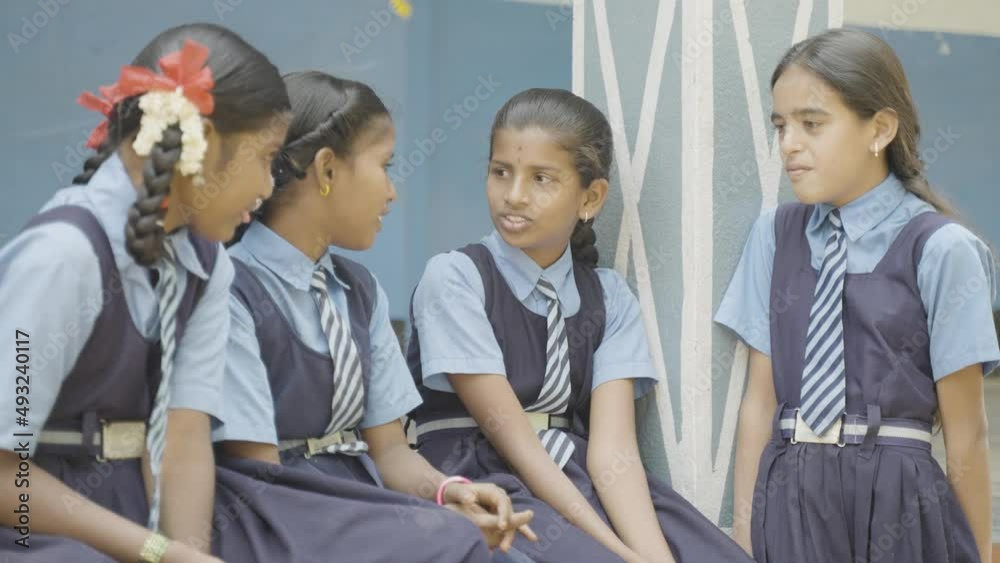 Happy group of girls talking with eachonther while sitting at school corridor during lunch - concept of break time, friendship, socialising and relaxation. Happy group of girls talking with eachonther while sitting at school corridor during lunch - concept of break time, friendship, socialising and relaxation.