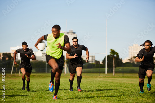 They cant keep up. Full length shot of a diverse group of sportsmen playing a game of rugby during the day. © Chanelle Malambo/peopleimages.com