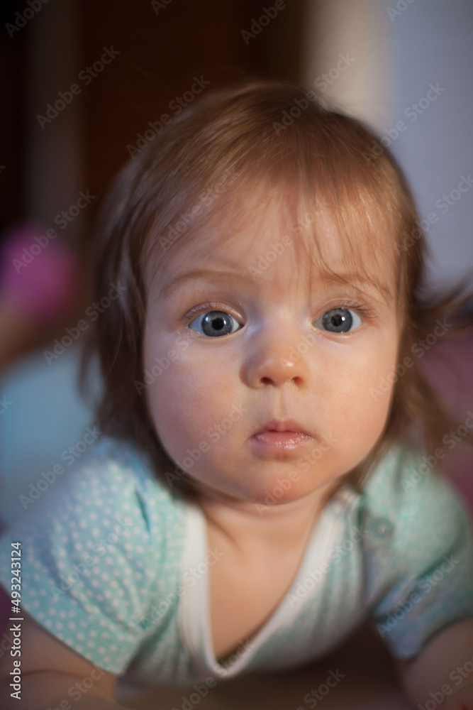 Little girl portrait at home. One-year-girl playing on floor