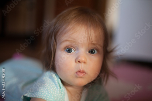 Little girl portrait at home. One-year-girl playing on floor