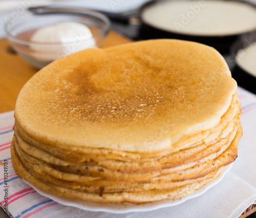 process of baking pancakes in pans on kitchen stove. stack of hot pancakes