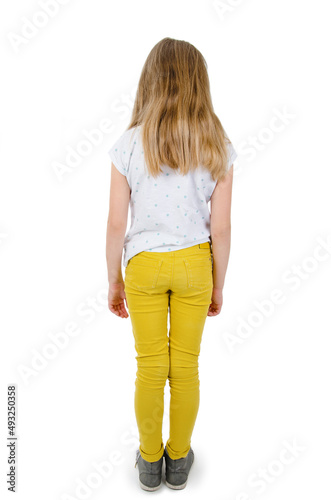 Rear view of modern little girl, standing. Isolated on white background. Back view. Full length of adorable teenage girl standing looking down.
