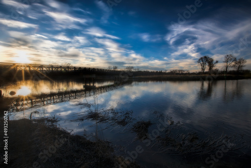 Beautiful soft sunburst sunset over bridge on Mallard Lake. Illinois.