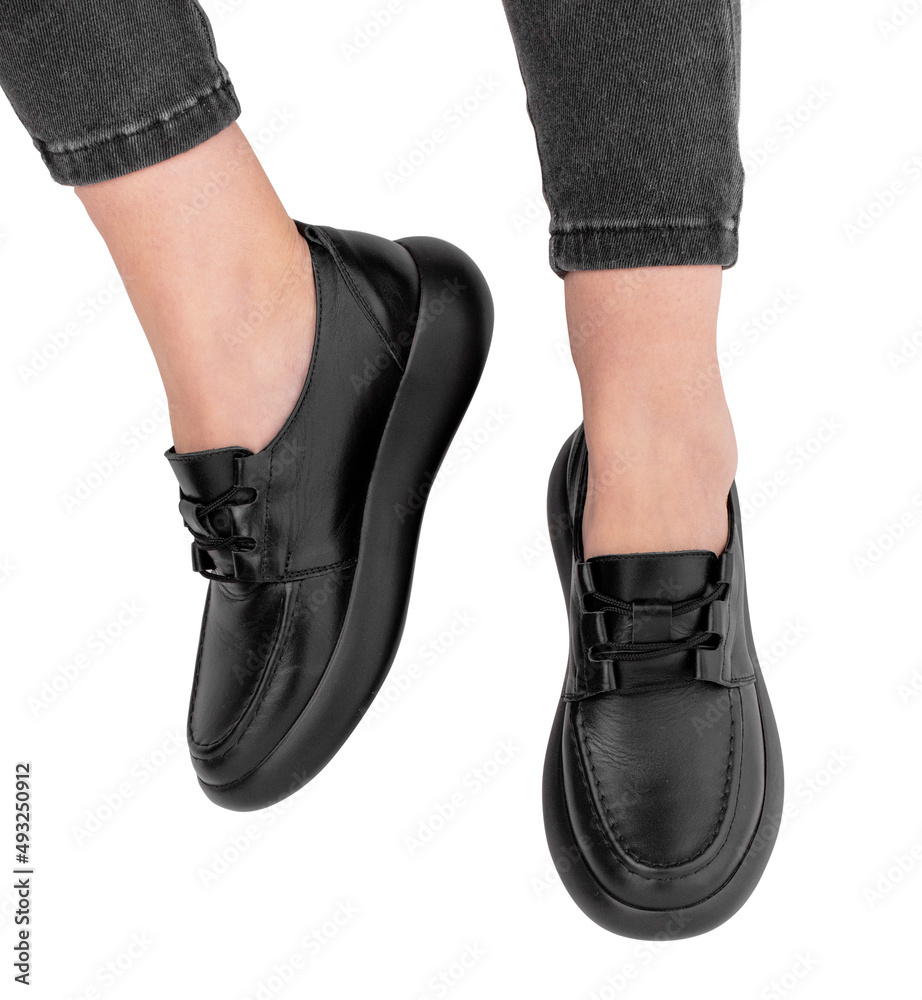 Women's legs in stylish sports shoes on a white background Women's legs in stylish sports shoes on a white background