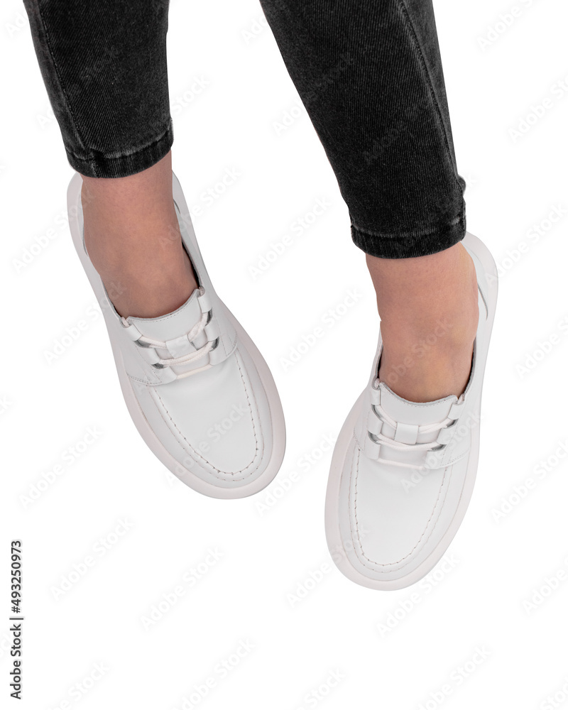 Women's legs in stylish sports shoes on a white background